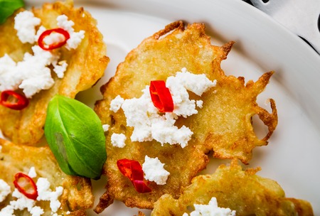 Fried potato pancakes with goat's curd, chili peppers and basilの写真素材
