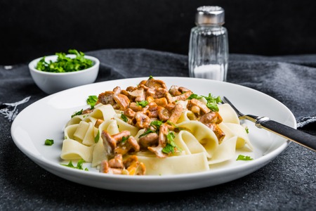 Pasta spaghetti with wild forest mushrooms chanterelle on white plateの写真素材