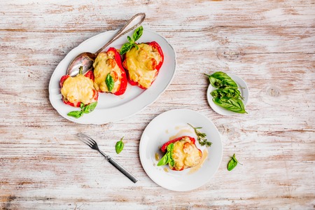 Stuffed peppers with meat and cheese on white plateの写真素材