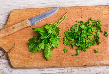 Chopped parsley leaf on a wooden tableの写真素材