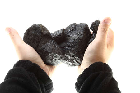 Pieces of coal in hand isolatedの写真素材