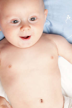 baby boy in diaper on white, blue eyeの写真素材