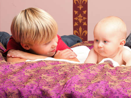 Blond boy with his newborn baby brother indoorの写真素材