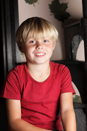 boy in red sitting on stairs, playing indoor
