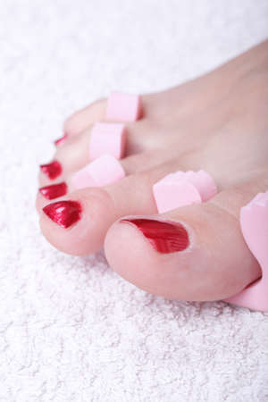 Close-up of female feet with red polished nails carefree, chiropodyの写真素材