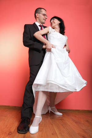 Happy smiling bride and groom on red backgroundの写真素材