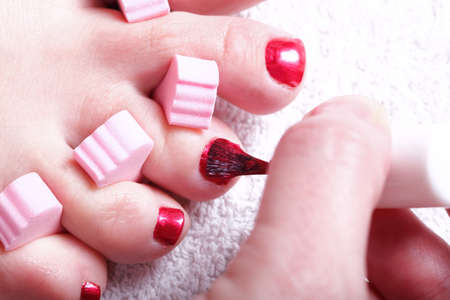 Close-up of female feet with red polished nails carefree, chiropodyの写真素材