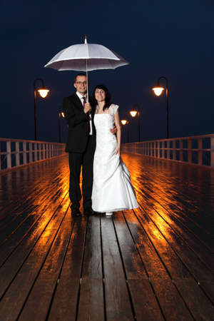 bride and groom, pier cloudy dusk sky.の写真素材
