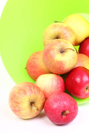 Fresh green, red apples in basket isolated over white background.の写真素材