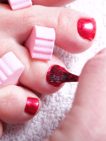 Close-up of female feet with red polished nails carefree, chiropodyの写真素材