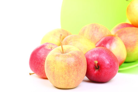 Fresh green, red apples in basket isolated over white background.の写真素材