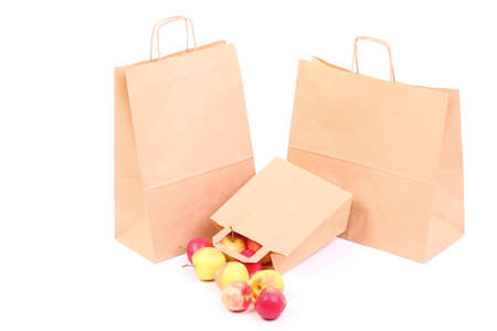 Shopping brown recycle gift bags and red apple isolated on white backgroundの写真素材