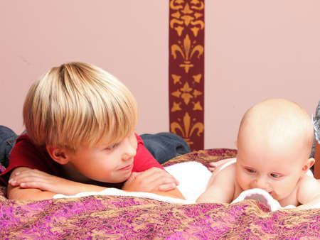 Blond boy with his newborn baby brother indoorの写真素材