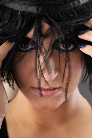 Beautiful Portrait of woman. Studio shot. Professional make up and hair style black featherの写真素材