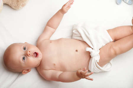 baby boy in diaper on white, blue eyeの写真素材