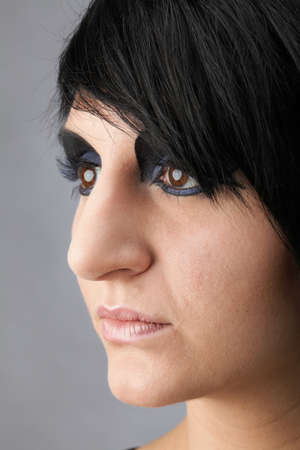 Beautiful woman face in studio. Blue and black. Grey background. Portrait of woman. Professional make up and hair style.の写真素材