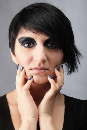 Beautiful woman posing in studio. Grey background. Portrait of woman. Studio shot of young beautiful woman on dark background. Professional make up and hair style.の写真素材