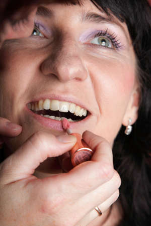 Close up of the woman paints face with makeupの写真素材