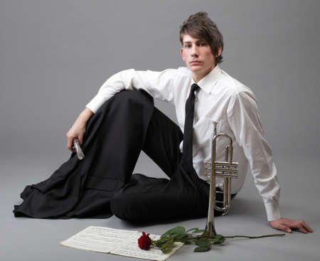 Portrait of a young jazz man andTrumpet grey background. Love melodyの写真素材