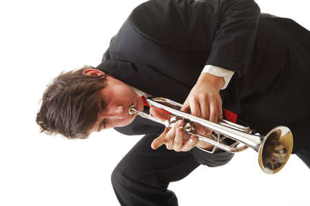 Portrait of a young jazz man playing his Trumpet white backgroundの写真素材