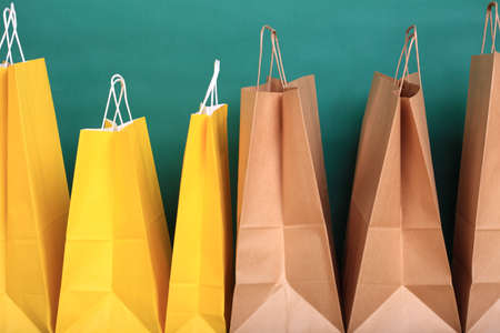 paper Shopping yellow gift bags on green background ecologocalの写真素材