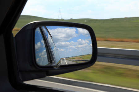 Road reflecting in the sideview mirror of a carの写真素材