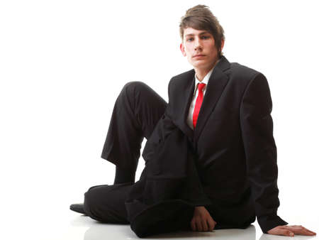 Fashion young businessman black suit casual red tie on isolated white backgroundの写真素材