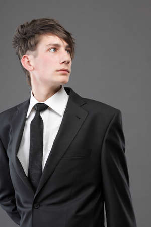 Fashion young businessman black suit casual tie on gray backgroundの写真素材