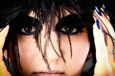 Beautiful Portrait of woman. Studio shot. Professional make up and hair style black featherの写真素材