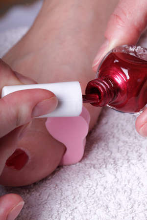 Close-up of female feet with red polished nails carefree, chiropodyの写真素材