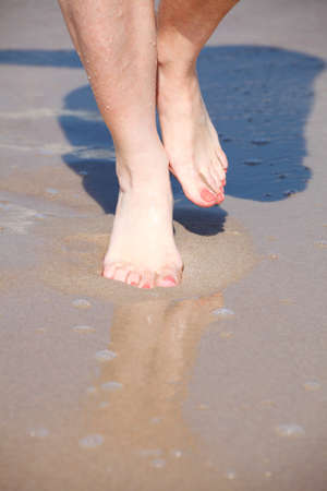 nice legs in water, nice pedicure red nail sand beachの写真素材