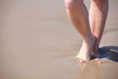 nice legs in water, nice pedicure red nail sand beachの写真素材