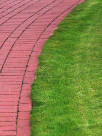 Garden stone path with grass growing up between and around stones, Brick Sidewalkの写真素材