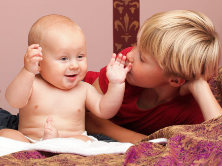 Blond boy with his newborn baby brother indoorの写真素材