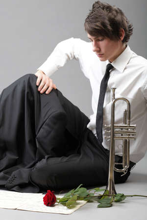 Portrait of a young jazz man andTrumpet grey background. Love melodyの写真素材