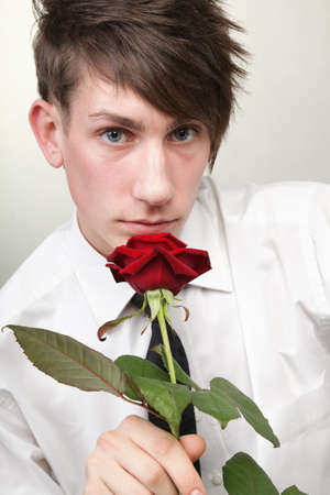 Portrait of a young man grey background. Love and rose.の写真素材