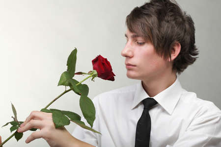 Portrait of a young man grey background. Love and rose.の写真素材