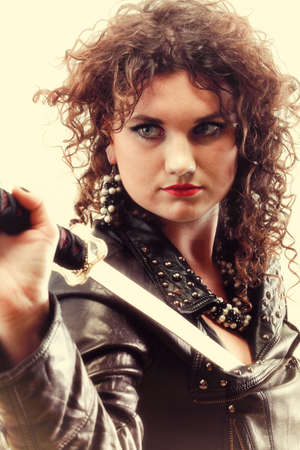 Girl - woman dark curly hair natural brown-haired holding in her hands a katanaの写真素材