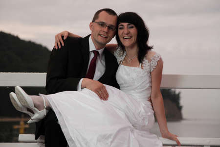 bride and groom, pier cloudy dusk sky.の写真素材