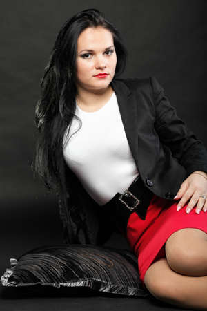 portrait of beautiful young brunette lies on black background.の写真素材