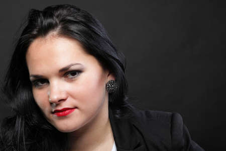 portrait of beautiful young brunette on black background.の写真素材