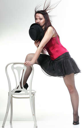 entertainment pastime girl dance in red corset chair white isolated showgirl,の写真素材