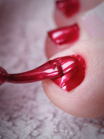 Close-up of female feet with red polished nails carefree, chiropodyの写真素材