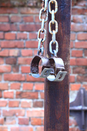 old fetters, manacles brick two old rusted iron rings on wall backgroundの写真素材