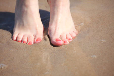 nice legs in water, nice pedicure red nail sand beachの写真素材