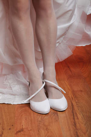 Bride fitting shoes on her wedding dayの写真素材