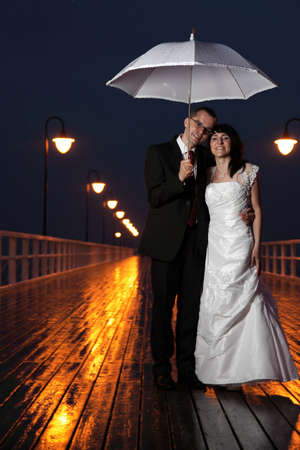 bride and groom, pier cloudy dusk sky.の写真素材