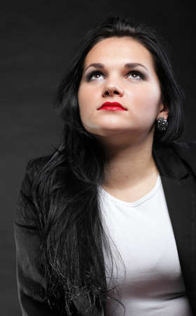 portrait of beautiful young brunette on black background.の写真素材