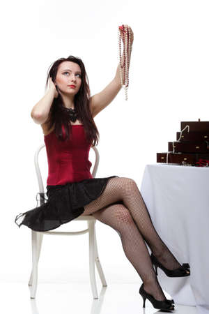 entertainment pastime girl dance in red corset chair white isolated showgirl jeweleryの写真素材