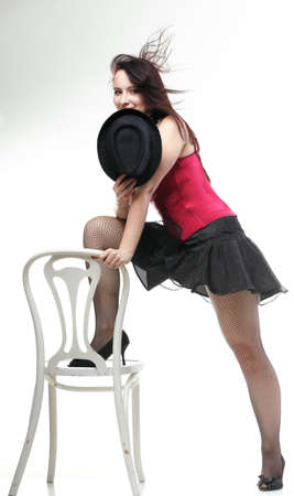 entertainment pastime girl dance in red corset chair white isolated showgirl,の写真素材